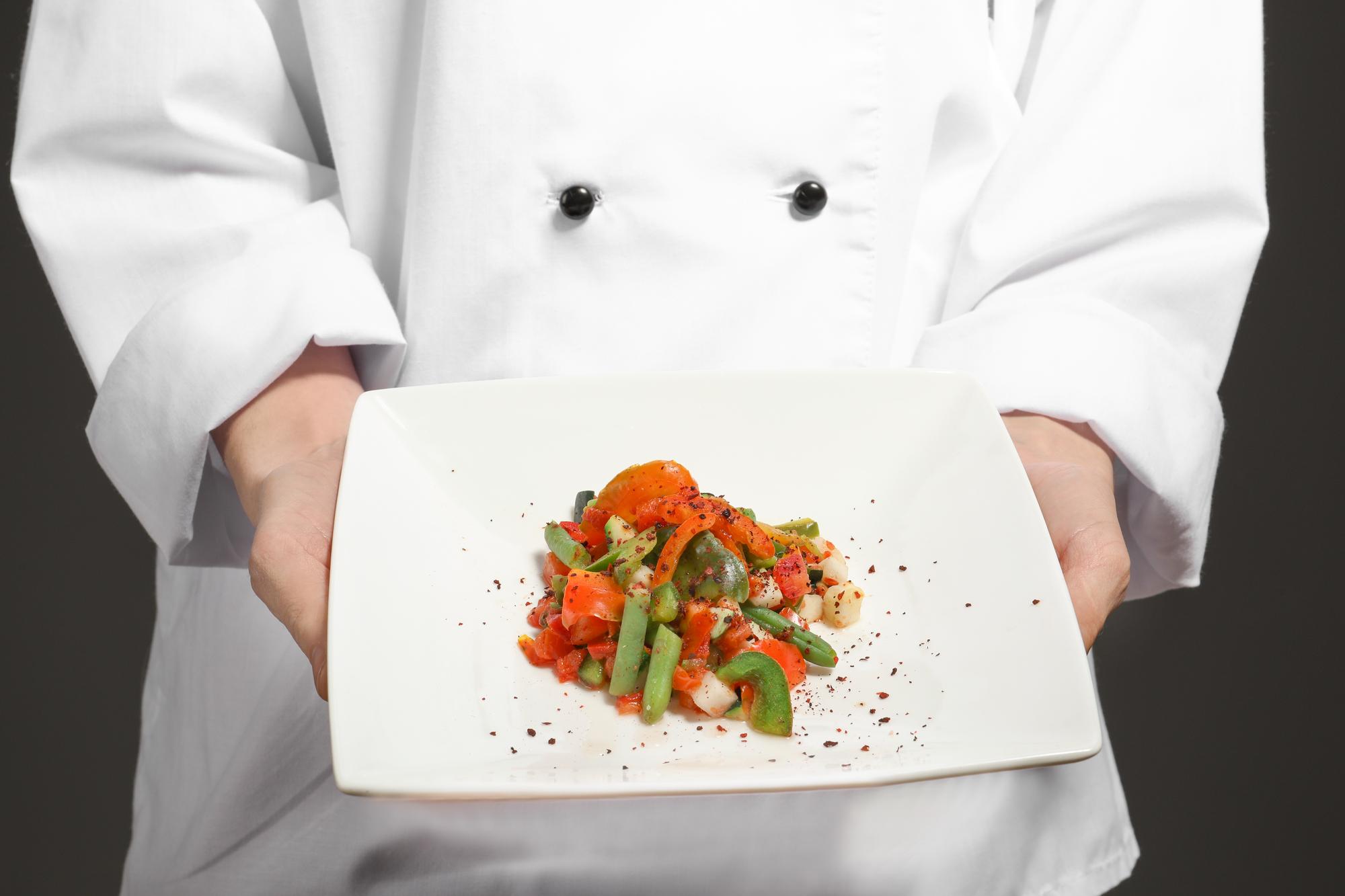 Chef al tavolo che mostra un piatto